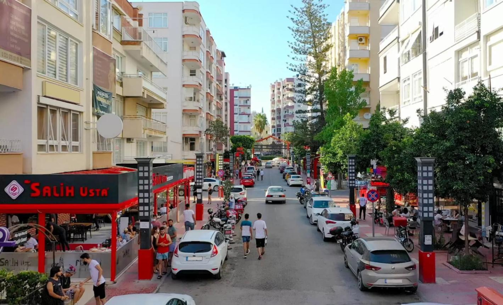 People walking through Mersin streets with shops, cafés, and local market activity.