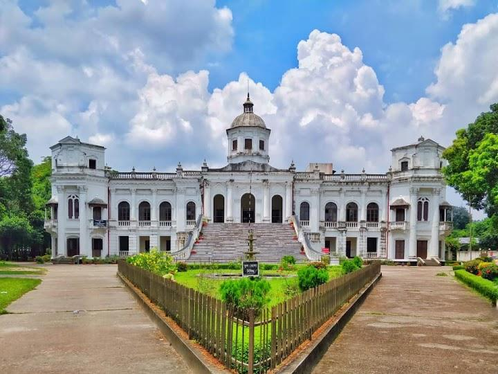 Visitors exploring Tajhat Palace in Rangpur, Bangladesh, a historic landmark with colonial architecture.