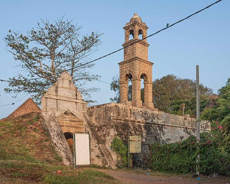 People walking along a lively street near the Dutch Fort area with colonial-era buildings and local shops.