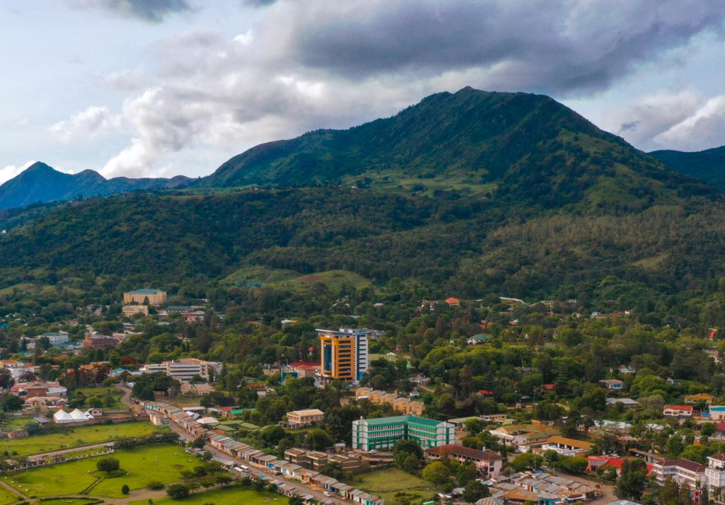 A panoramic aerial view of Mbeya showing the cityscape surrounded by mountains and green valleys in Tanzania
