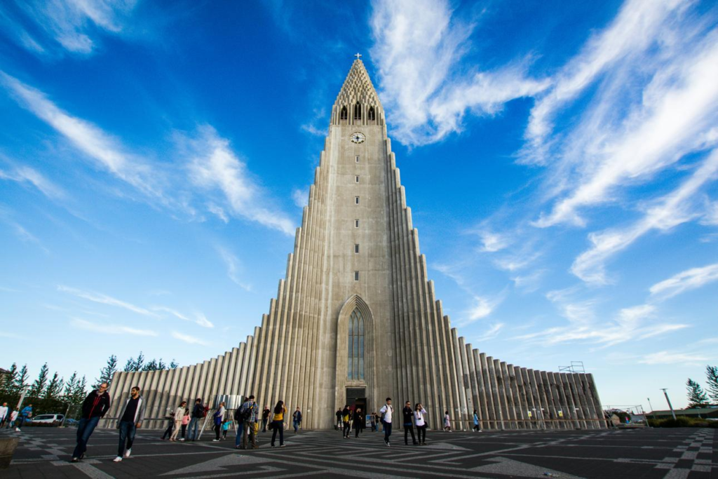 Visitors exploring Hallgrímskirkja Church in Reykjavík, Iceland, showcasing its iconic architecture and city views.