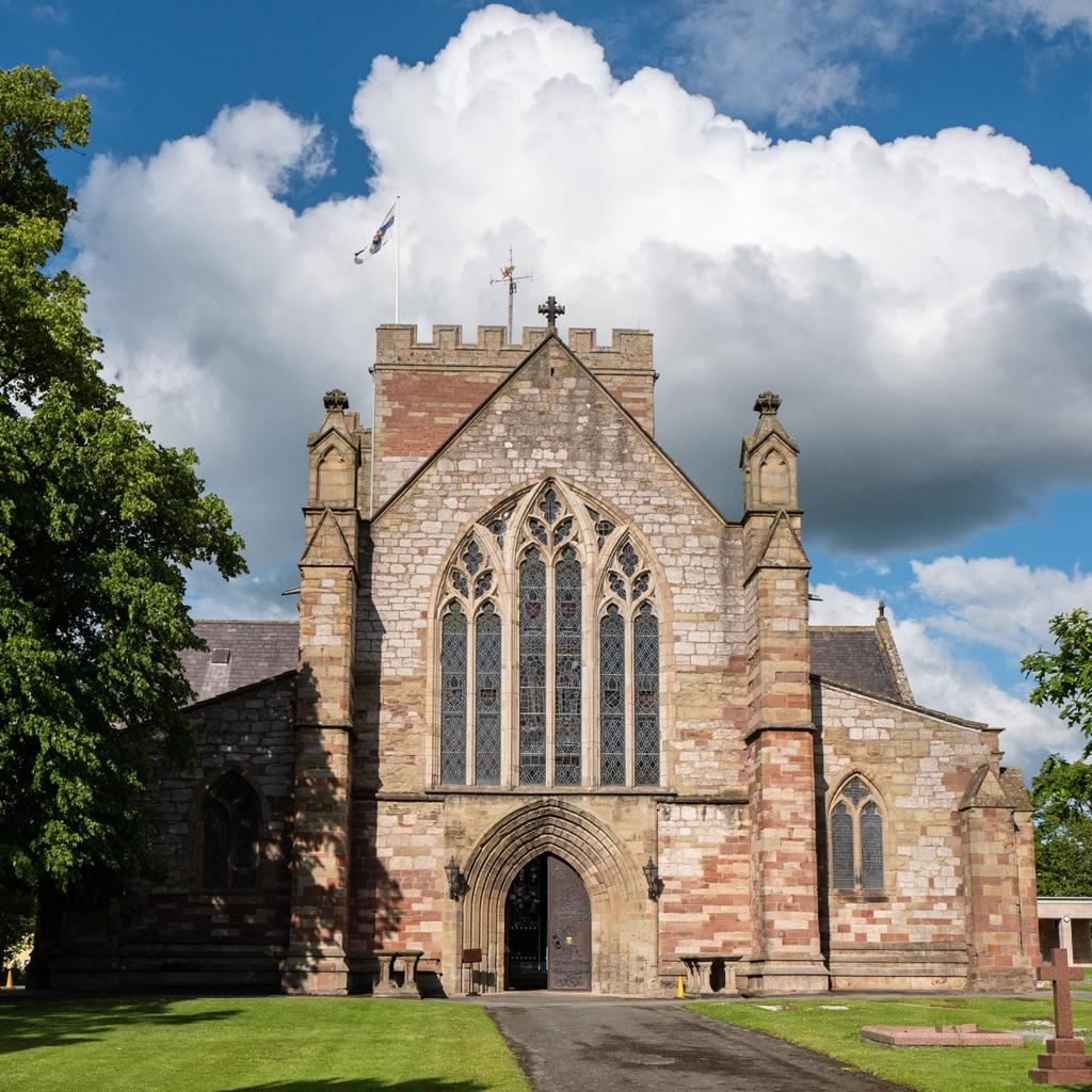 Visitors exploring Saint Asaph Cathedral in Wales, a historic landmark of religious and cultural significance.