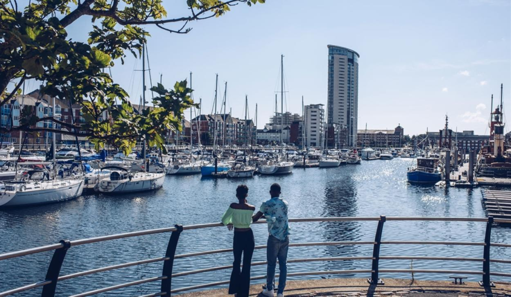 Visitors enjoying Swansea Marina in Wales, UK, with waterfront views and leisure activities.