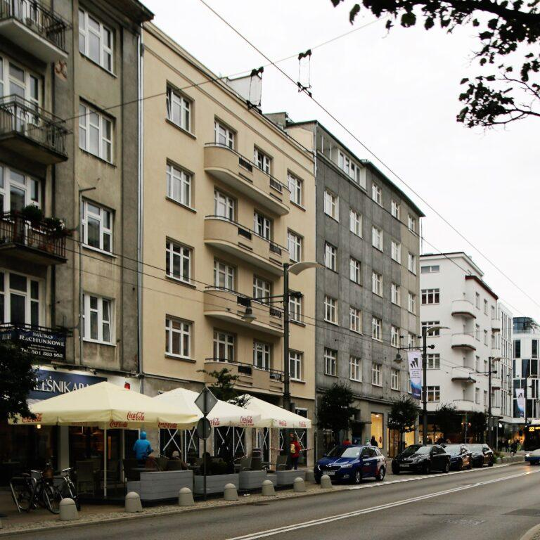 People walking through Gdynia streets with shops, cafés, and local market activity.