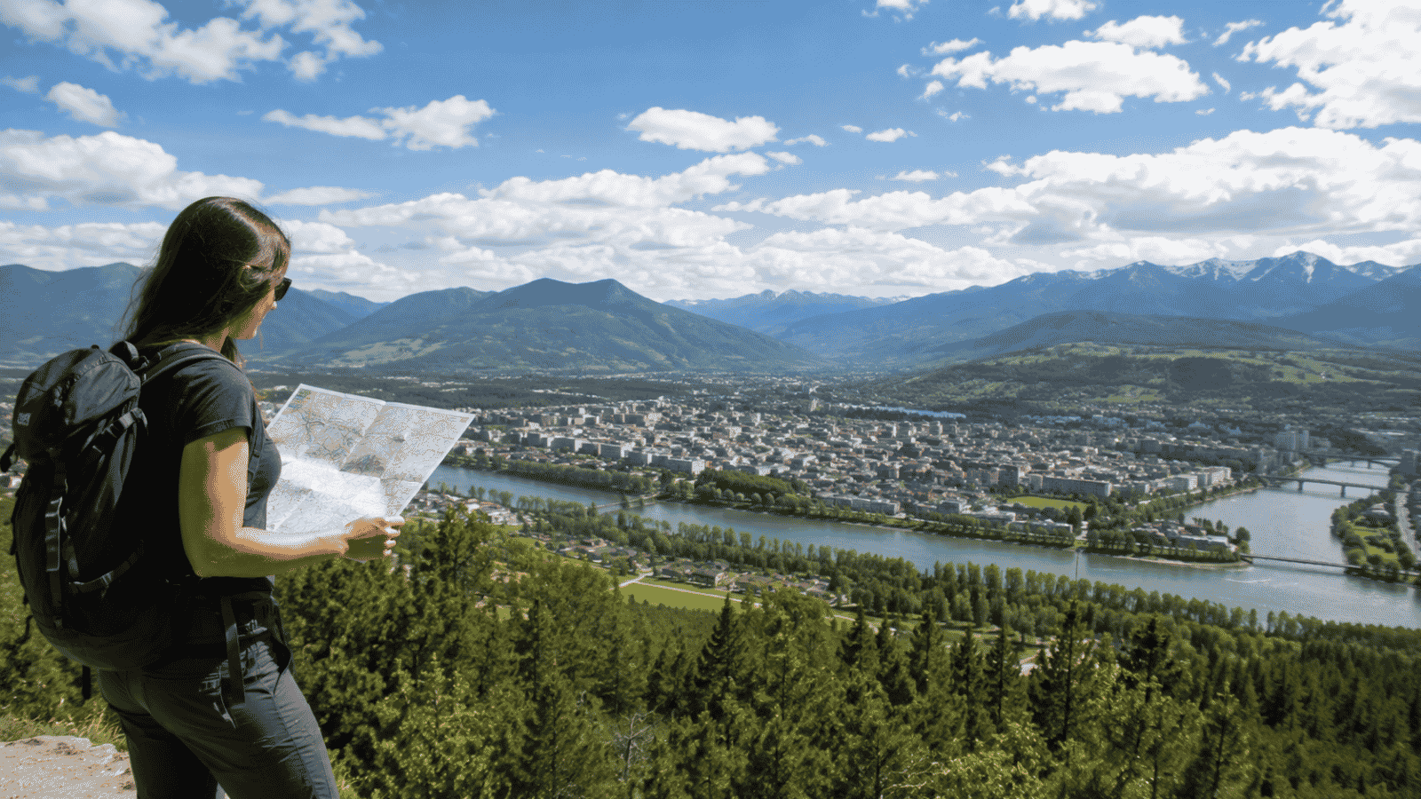 International traveler studying destination information while overlooking a vibrant city surrounded by natural landscapes.